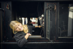 En pige, der sidder i et lokomotiv